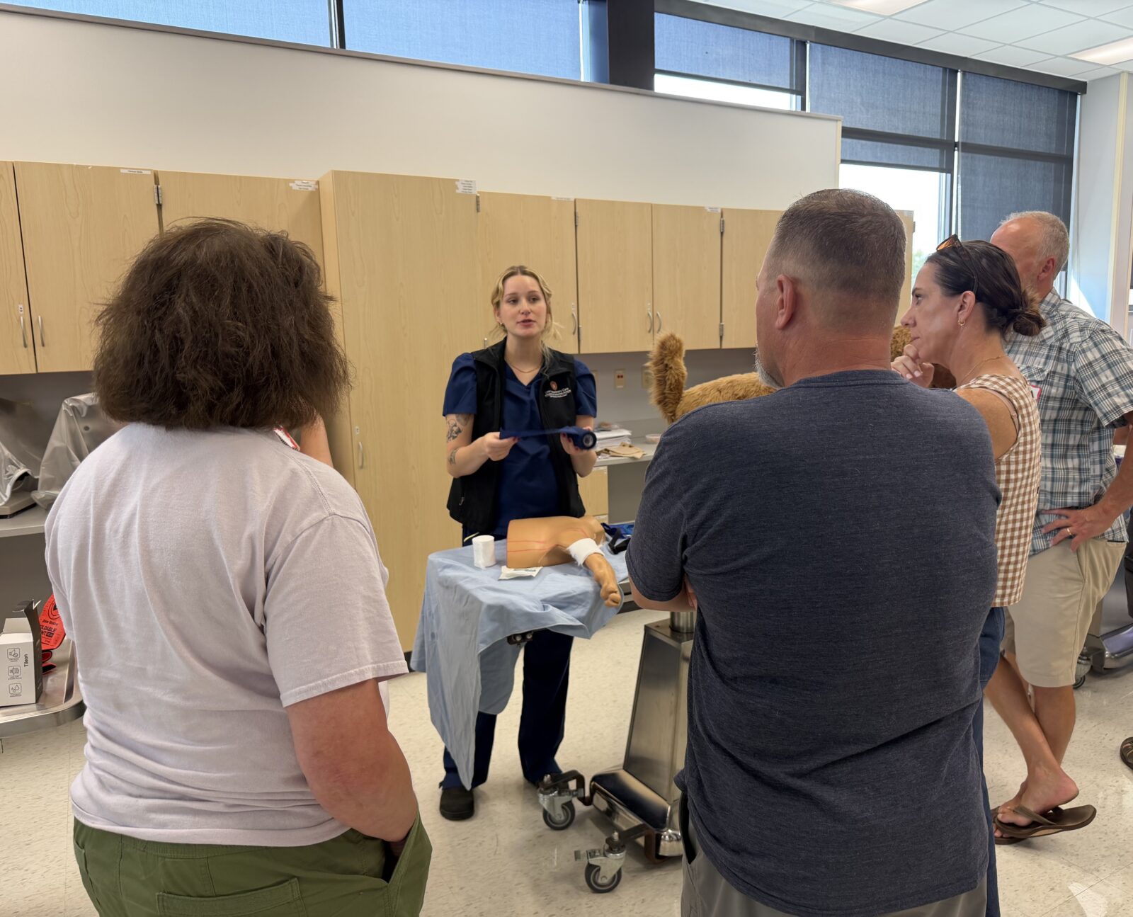Katie, outreach program coordinator, discusses proper wound bandaging with clients; First Aid Basics class; August 2026